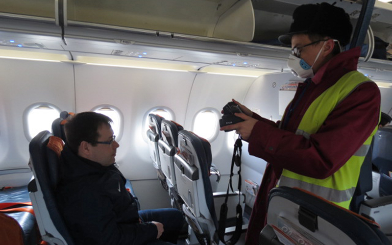 Сотрудник СКП в аэропорту Оренбурга проводит дистанционную термометрию пассажиров прибывшего рейса